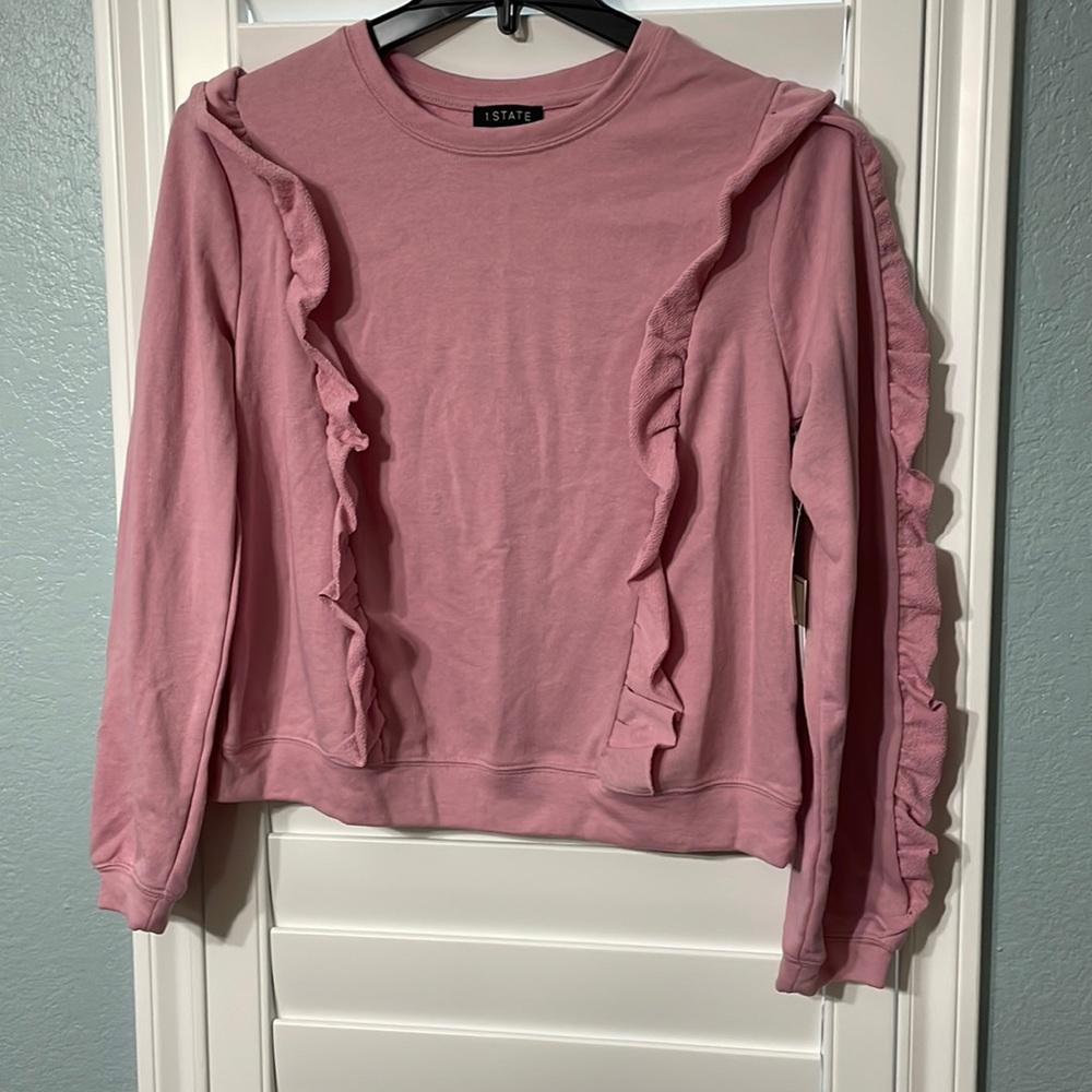 Pink long sleeve with ruffled arms.